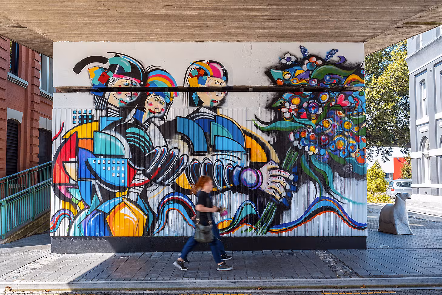 People pass by cool artwork in Dunedin, one of the best things to do in Dunedin.